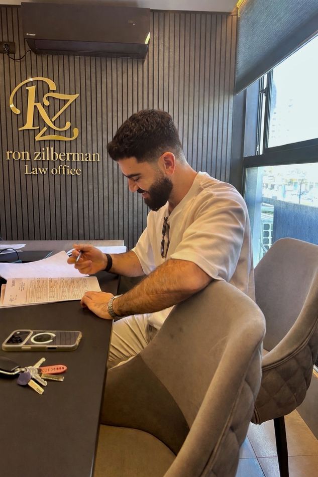 יובל אוזנה חותם על חוזה במשרד עורך דין